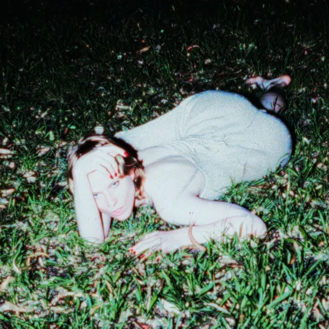 ETERNAL TWINK cover: Eva lying on grass at night, lit by a flash